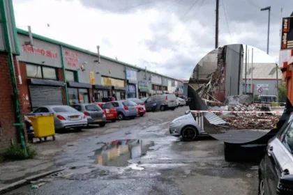 Bury New Road fire destroys the Marc Darcy showroom in Salford as crews tackle hotspots, roads remain closed and police investigate the scene.